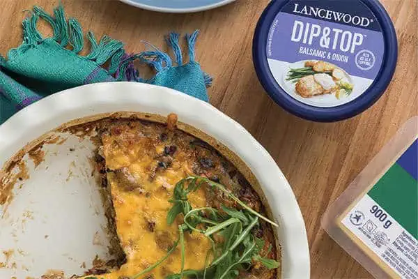The Ultimate Heritage Day Food Guide: Easy biltong quiche recipe served in a white dish with melted cheese topping and rocket garnish