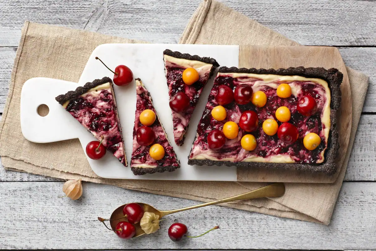 9 Decadent Winter Dessert Recipes and 1 Savoury Cheesecake Twist Berry swirl cheesecake tart with a chocolate biscuit base and fresh fruit